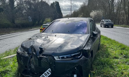 Black BMW in the central grassed area of a road after it crashed