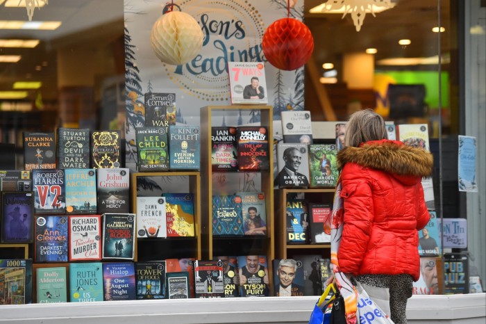 A woman looks at the window display of a Waterstones branch