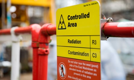 A radiation warning sign on a railing near the pile fuel storage pond