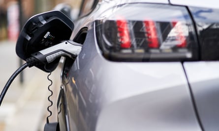 A Peugeot electric car plugged into an EV charging point