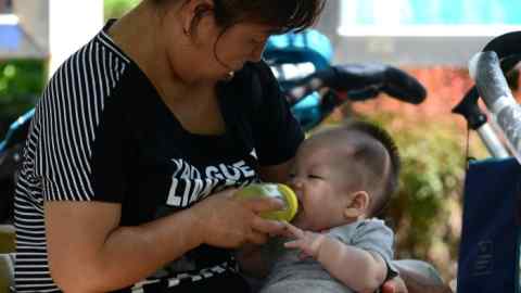 Woman bottle feeds a baby