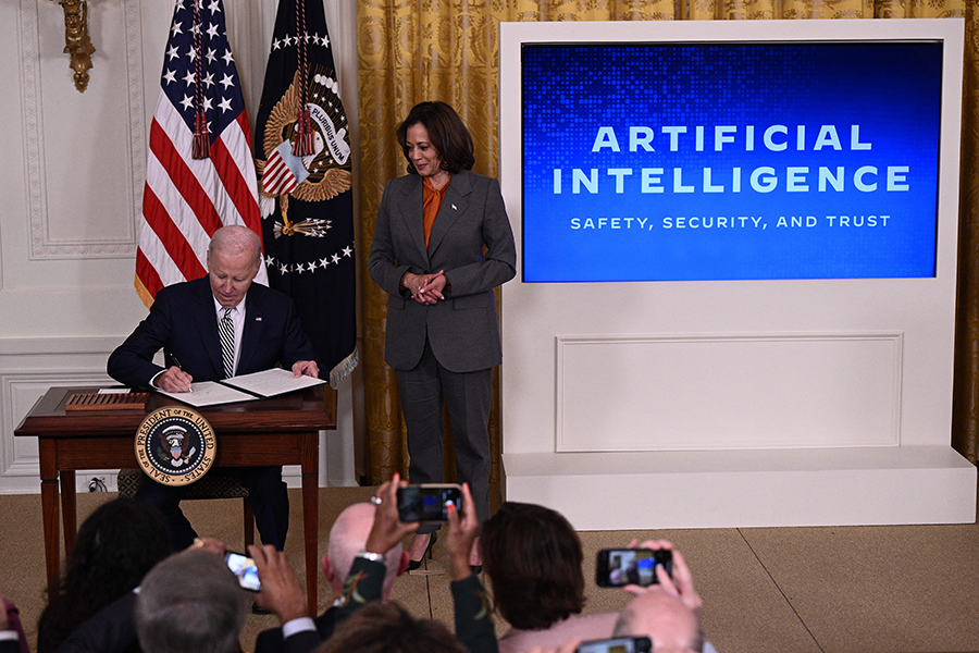 With U.S. Vice President Kamala Harris (R) looking on, U.S. President Joe Biden signs an executive order on advancing the safe, secure, and trustworthy development and use of artificial intelligence at the White House on October 30.  (Photo by Brendan Smialowski/AFP via Getty Images)