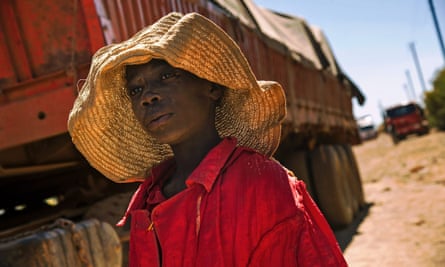 A child walks past a truck carrying rocks extracted from a cobalt mine at a copper quarry and cobalt pit in Lubumbashi, DRC.