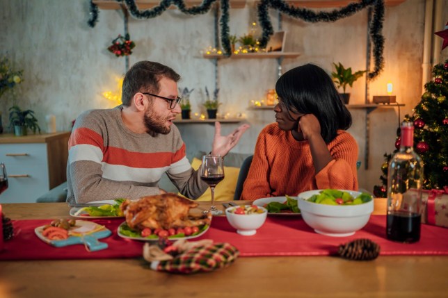 Two people having an argument at the Christmas dinner table.