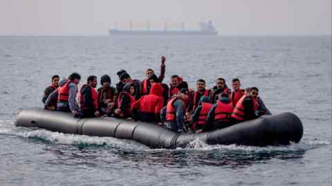 An inflatable craft carrying migrants crosses the shipping lane in the English Channel on August 4, 2022 off the coast of Dover, England