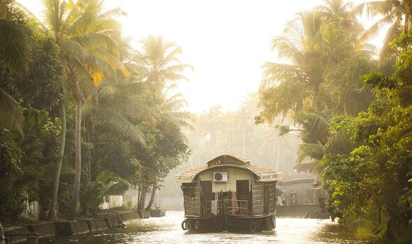 Houseboat tourist boat trip on an excursion in the Kerala backwaters at sunset