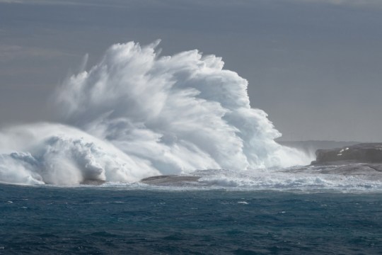 Large wave crashing onto rocks