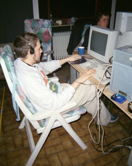 Young men sitting at computers in sun loungers in what looks like a conservatory