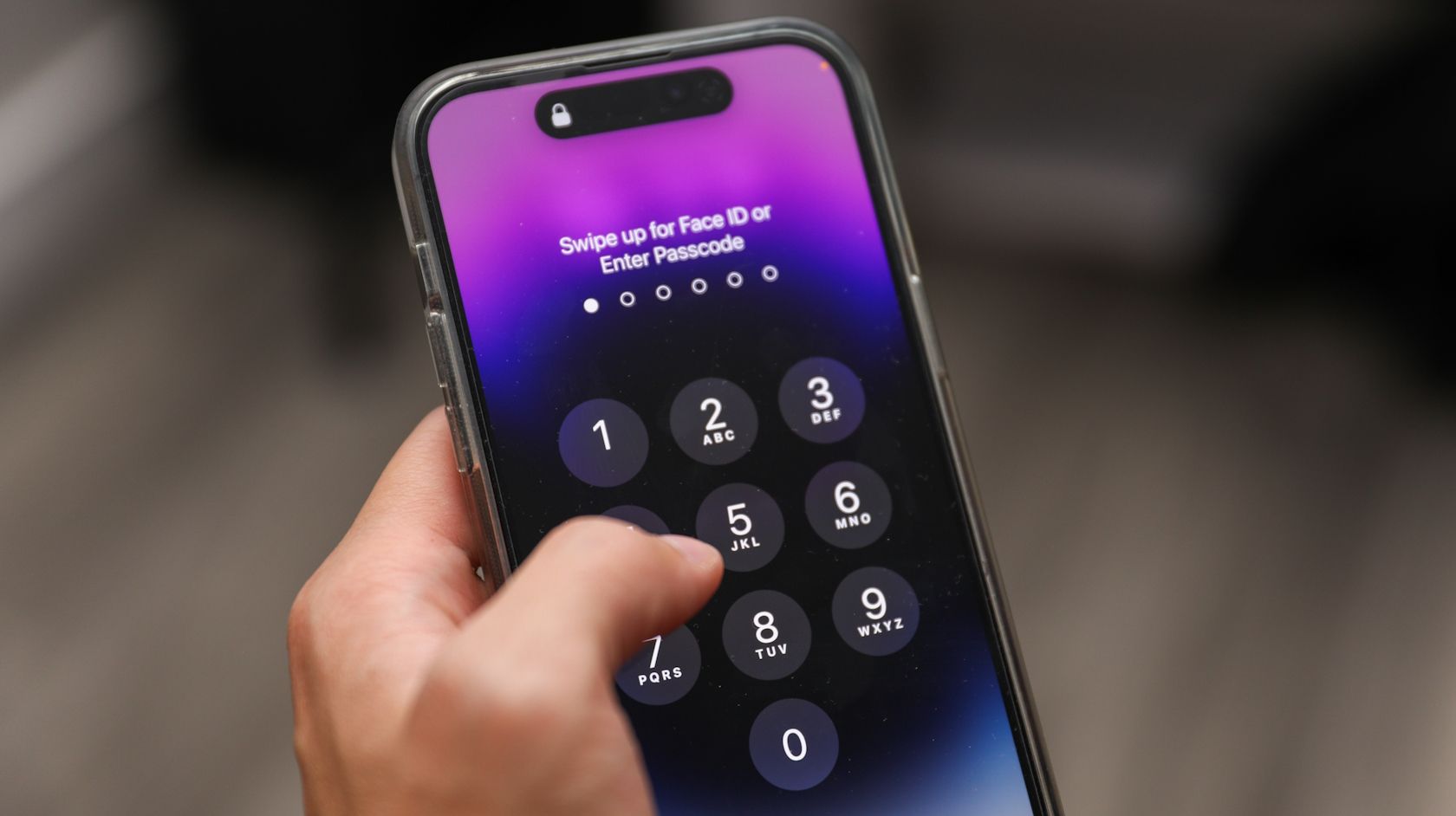 person trying to unlock an iPhone 14 Pro