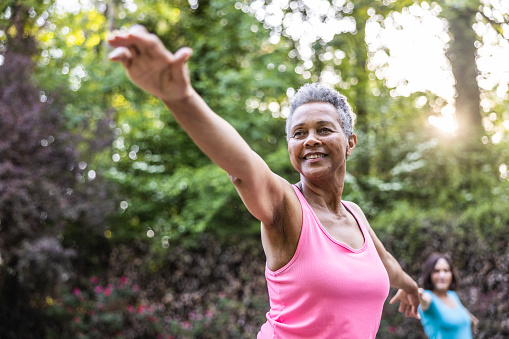 Senior women taking a yoga class in beautiful garden