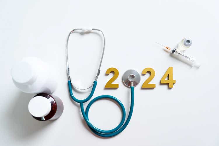 Golden wooden numbers 2024 and stethoscope, Happy New Year for health care.heart health, health insurance concept, new year resolutions goal.medicine treatment and yearly health checks.