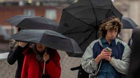 Pedestrians cross Millennium Bridge in London amid Storm Gerrit