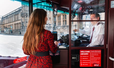 A woman in a red and black dress pays the driver her fare  