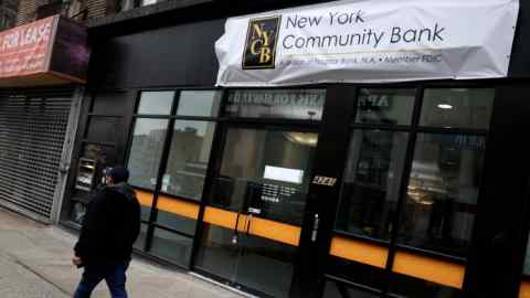 Person walks by a New York Community Bancorp location