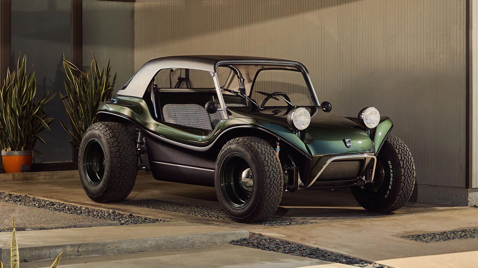A static front-quarter shot of a green Meyers Manx 2.0 EV parked at a modern house.