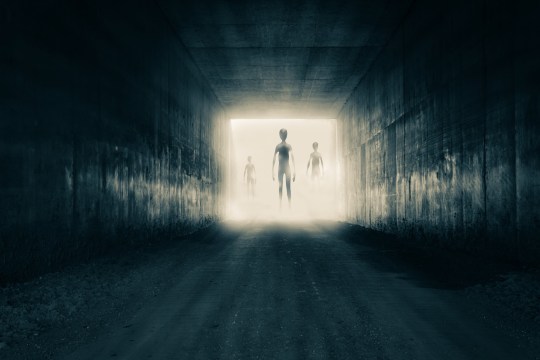 A group of aliens emerging from the light at the end of a dark sinister tunnel. With a high contrast edit.
