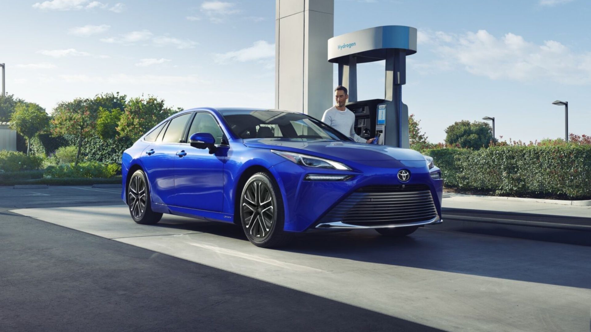 2024 Toyota Mirai, front quarter view, blue, at charging station with man outside