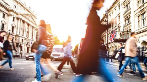 Getty Images People walking quickly across a road