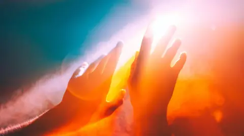 Getty Images Photo of two hands held up to the sunshine