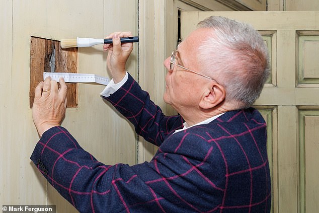 Professor Murray Pittock of the University of Glasgow with the hole, which measures just 2.1cm (0.8 inches) in width