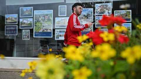 A pedestrian passes an estate agents’ window