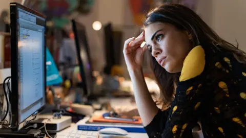 Getty Images Stock image of a female office worker looking at her PC screen with an exasperated expression