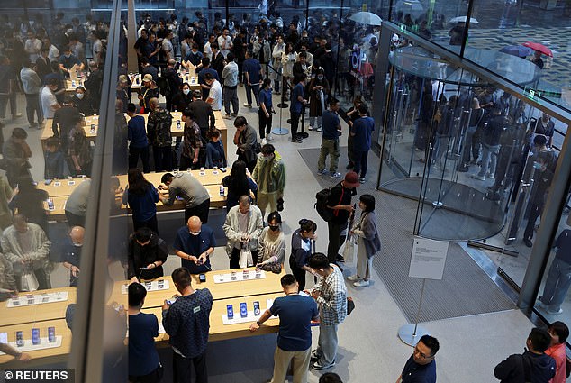 BEIJING, CHINA: It's a busy day for Apple employees whenever a new iPhone goes on sale. In Beijing, customers line Apple's shelves while many more wait in the rain