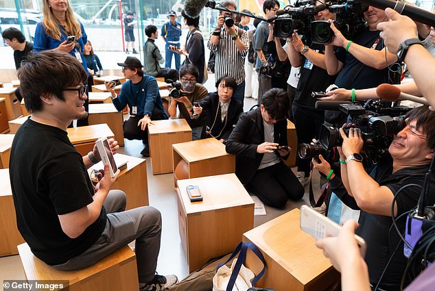 TOKYO, JAPAN: The first customer holds his iPhone 16 Pro as he poses to the media after purchasing it at the Apple Omotesando store in Tokyo, Japan this morning