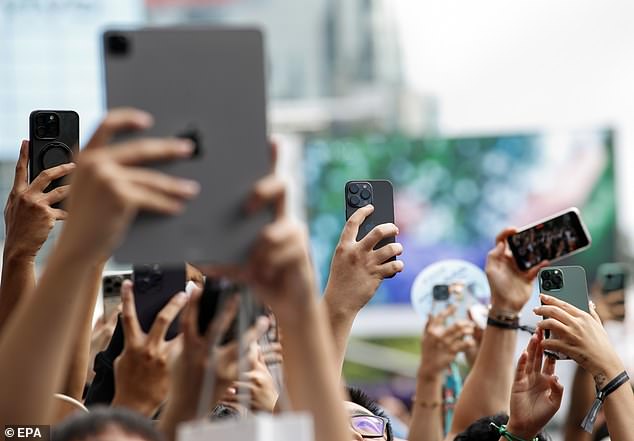 BANGKOK, THAILAND: Customers use their devices to film the moment their local Apple store opens