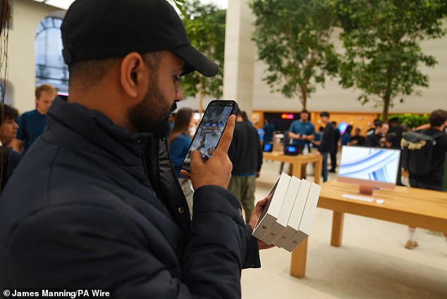 LONDON, ENGLAND: That'll be £3,500 please! A London customer stocks up with four of the new iPhones