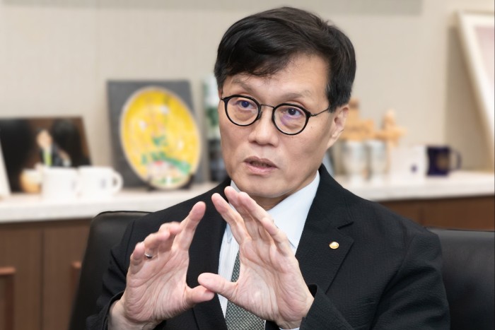 Rhee Chang-yong is seated indoors and gesturing with his hands while speaking