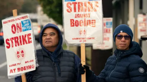 Getty Images Boeing workers on a picket line near the entrance to a Boeing facility in Seattle, Washington. 