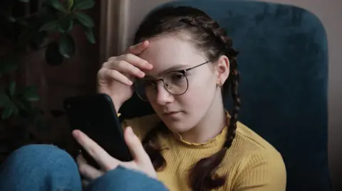 Getty A stock image of a girl looking at a phone