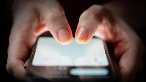 Getty Images Thumbs above a lit up phone screen