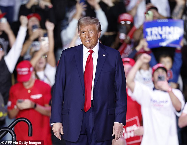 Experts told DailyMail.com that at this point in the campaign, Mr Trump is 'low energy'. He is pictured at a campaign rally in Grand Rapids, Michigan