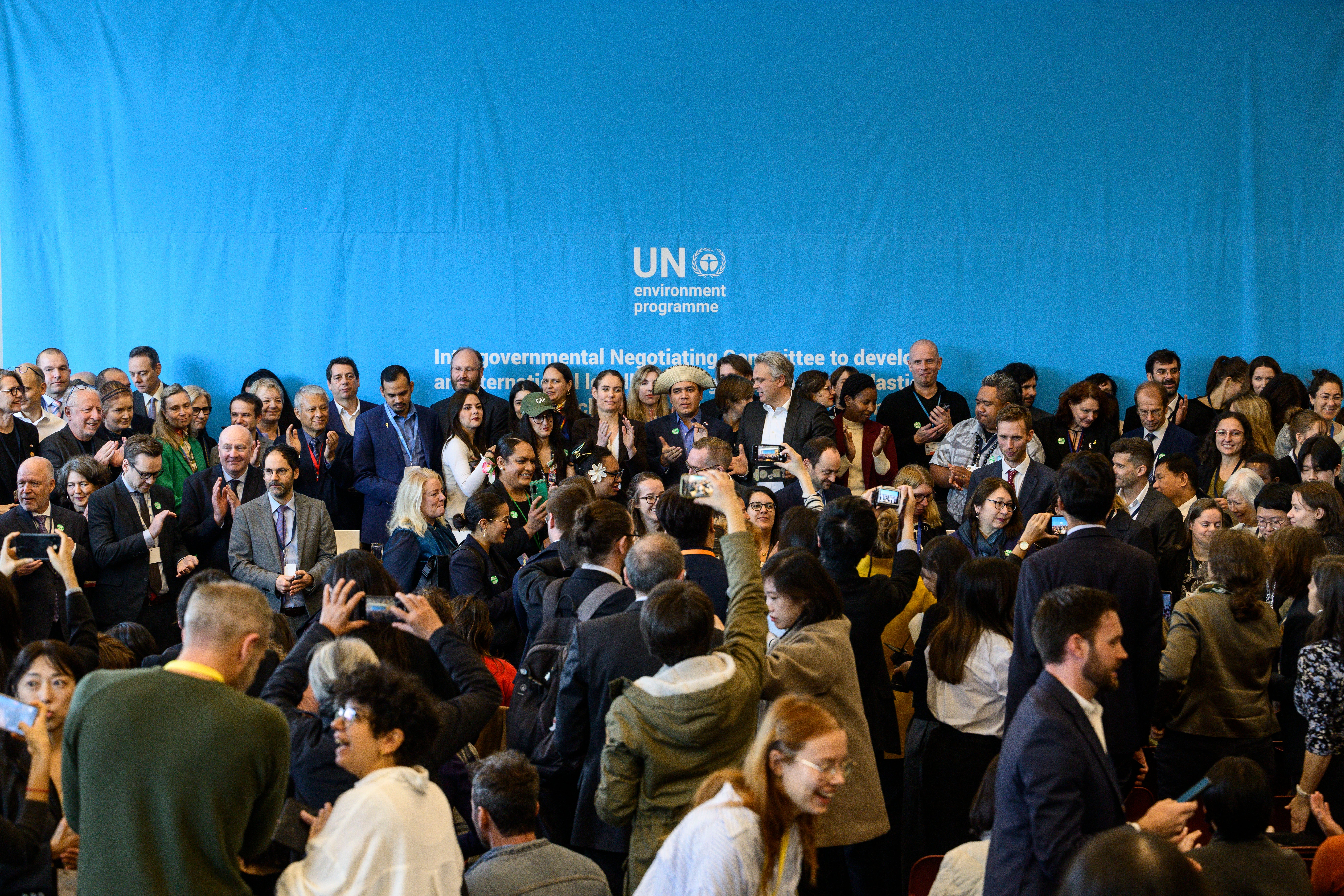 Delegates pose for a group photo at the end of a member state press briefing during the fifth meeting of the Intergovernmental Negotiating Committee to develop an international legally binding instrument on plastic pollution (INC-5) in Busan