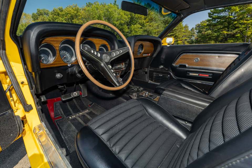 The muscle motor features a wooden steering wheel and dashboard