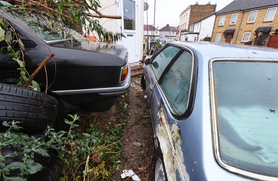 Two rusty, peeling off cars blocking each others exits