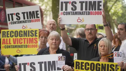 PA Media File photo dated 26/7/2023 of campaigners, including many who are personally infected and affected by infected blood, gather in Westminster, London, calling for compensation