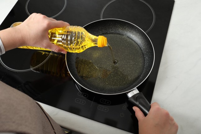 Woman pouring cooking oil from bottle into frying pan on stove, above view